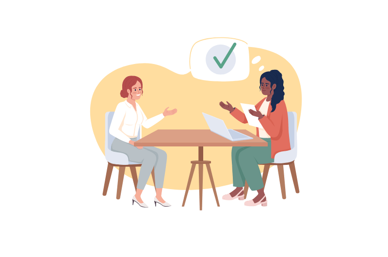 Two women speaking to each other at a table.